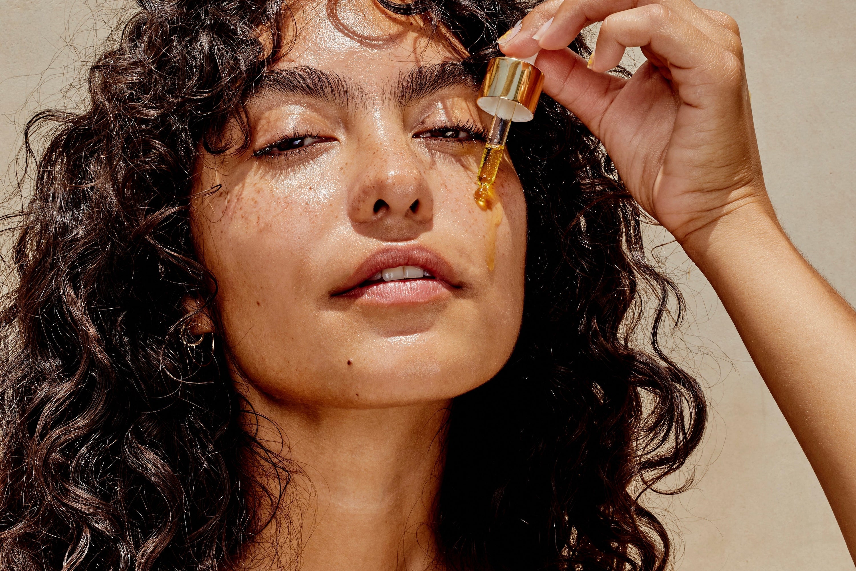 woman applying CBD oil to her face