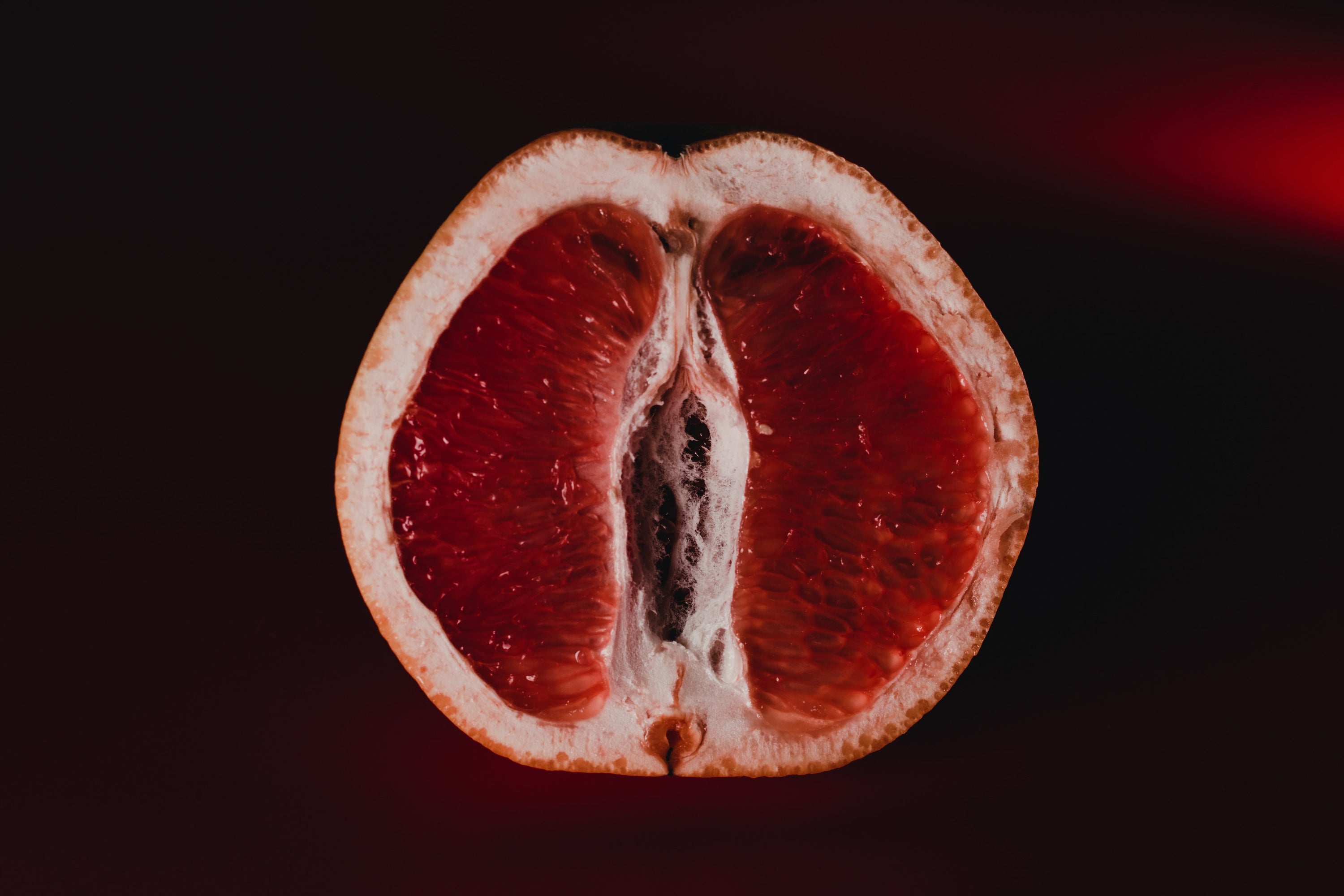 grapefruit as a sexual concept, dark background