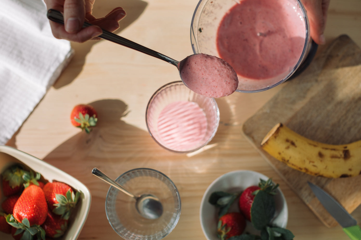 woman preparing nice cream in kitchen with fruit